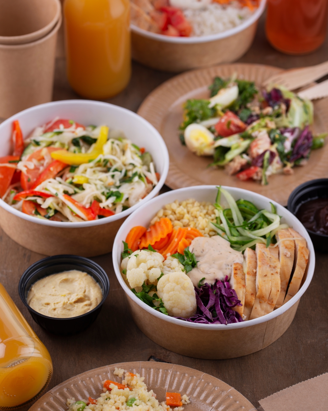 Multiple carry out containers filled with vegetable, greens, and meats sitting on a table - Dogfish Packaging