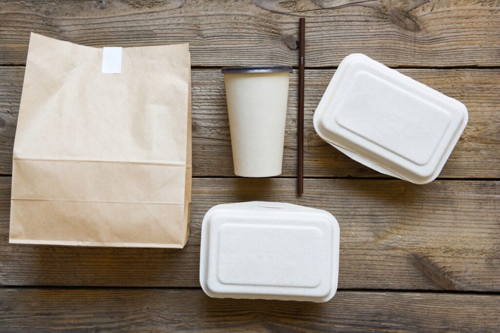 Several light colored Dogfish Packaging takeout containers on display.